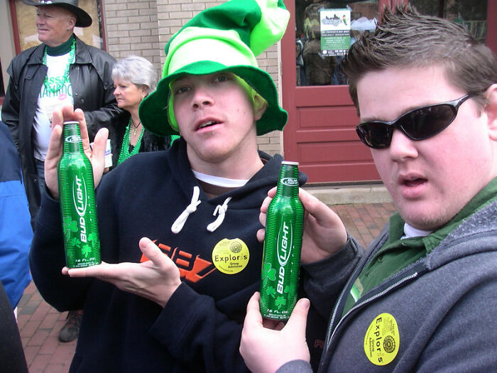 Two men holding Bud Light bottles at a casual outdoor event, illustrating bartenders’ insights on drink orders.