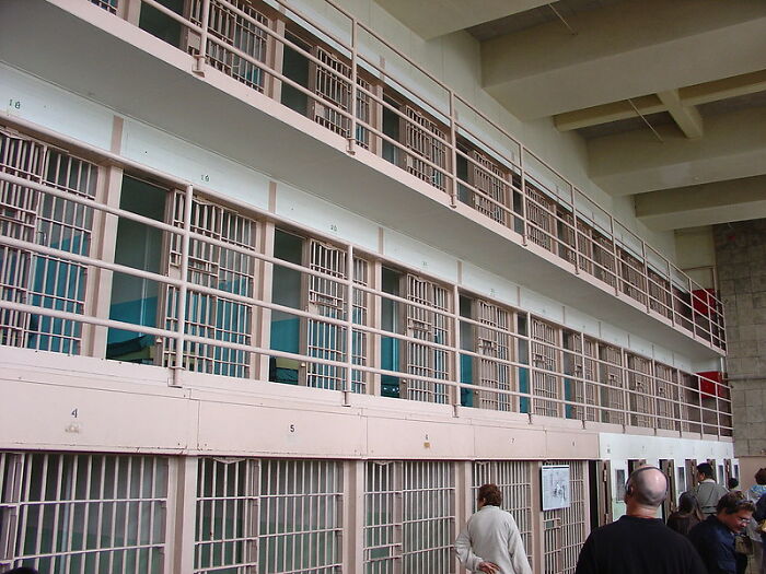 Interior view of prison cells with bars and former prisoners, highlighting experiences of incarceration and prison life lessons.