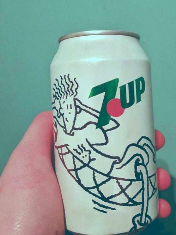 Hand holding a vintage 90s 7UP can with a retro design on a green background.
