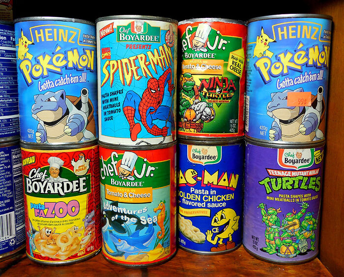 Cans of 90s nostalgic foods featuring Pokémon, Spider-Man, and Ninja Turtles on a shelf.