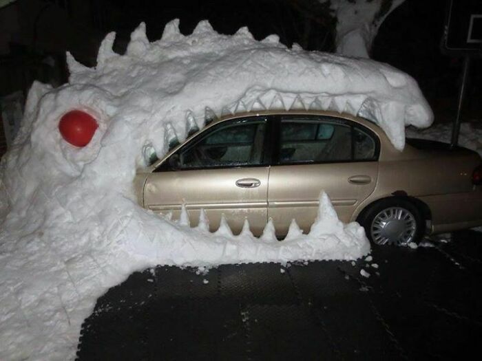 Snowman design created around a car shaped like a giant open-mouthed creature with red eyes and sharp teeth.