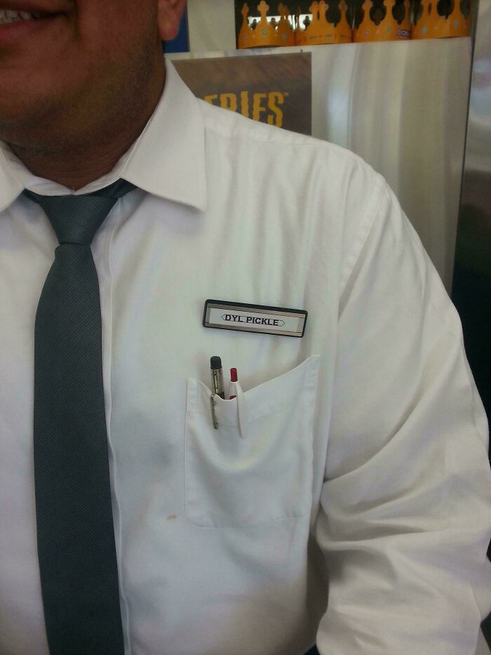 Man wearing white shirt and tie with a name tag displaying a dumb name, illustrating dumbest names encountered by parents.