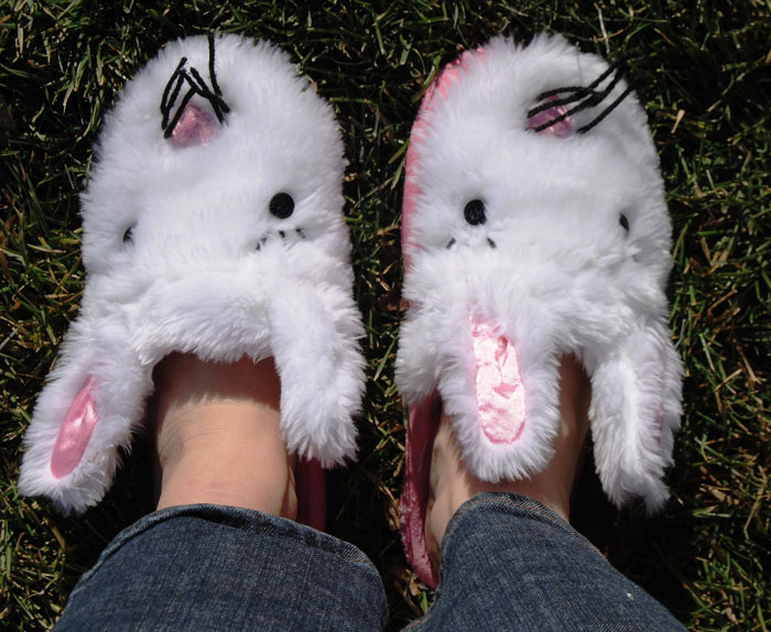 Person wearing white fluffy bunny slippers on grass, illustrating comfort and home life before incarceration challenges.