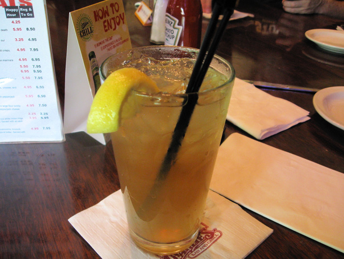 Iced tea with lemon and straw on a table in a bar setting, related to bartenders and drink orders insights.