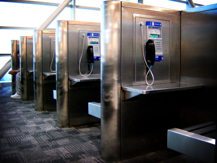 Row of public payphones in a modern setting, illustrating communication in stories shared by lawyers in an online group.