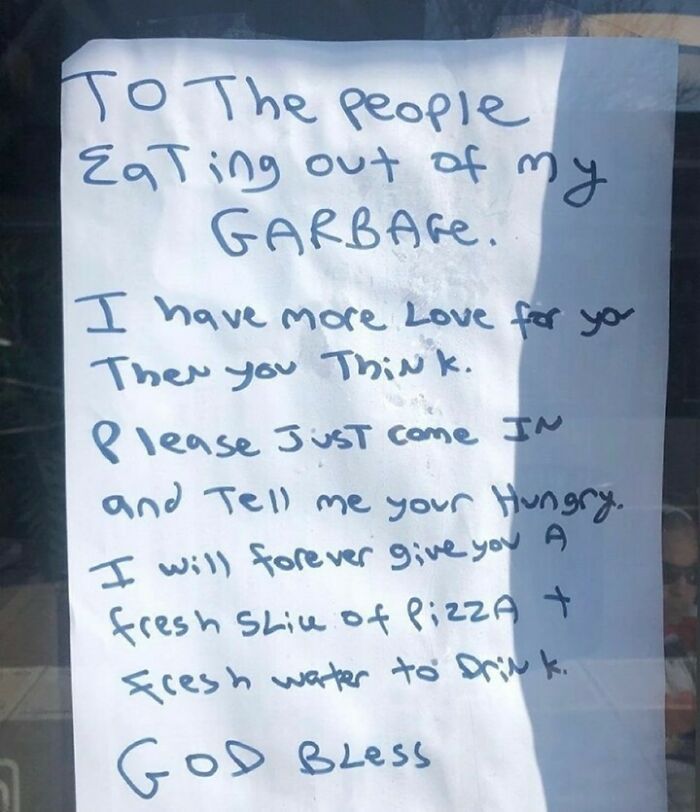 Handwritten note offering pizza and water to people eating from garbage, a heartwarming picture from wholesome internet content.