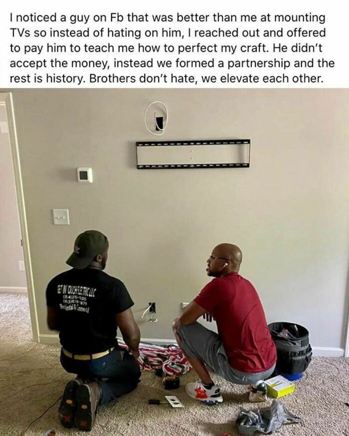 Two men kneeling in front of a wall mount, showing a heartwarming picture from wholesome meets the internet to lift spirits up.