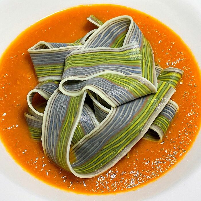 Striped pasta design served over smooth tomato sauce, showcasing unique pasta creativity by a skilled chef.