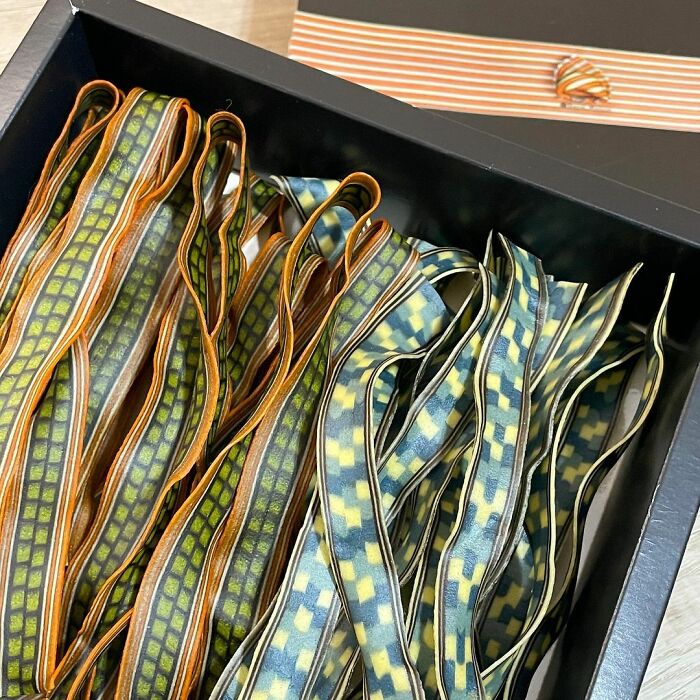 Unique pasta designs with intricate checkered patterns in orange, green, and blue hues, showcasing creative pasta artistry.