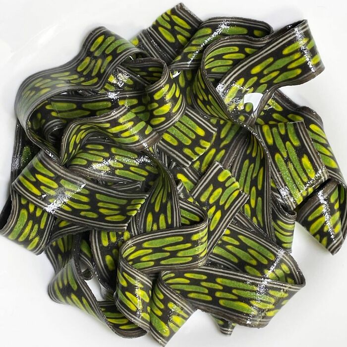 Unique pasta designs with vibrant green and black patterns, showcasing an innovative and artistic chef's creation.