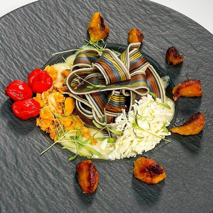 Colorful unique pasta designs plated with garnishes and sauce, showcasing creative culinary presentation by the chef.