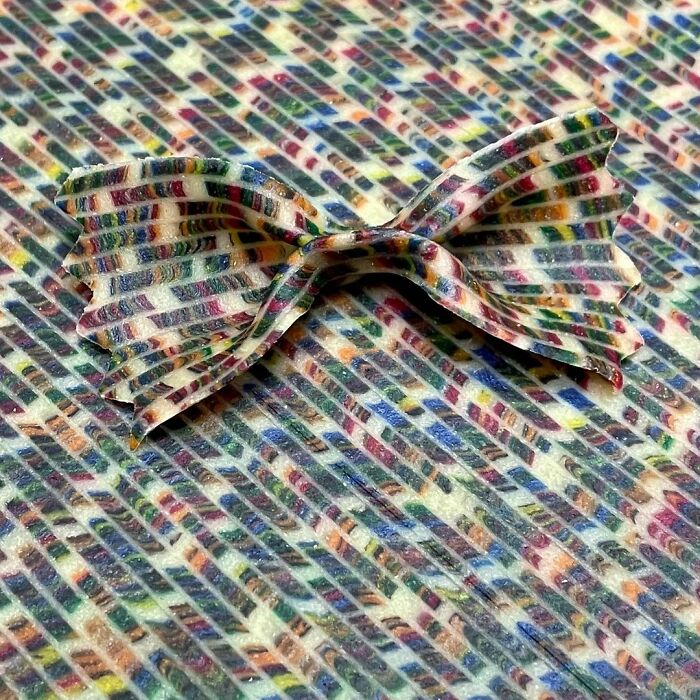 Colorful unique pasta design shaped like bow tie on matching patterned background by creative chef.
