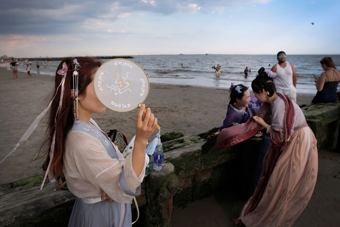 Women in traditional dress near the beach, captured in one of the most powerful street photos by AAP Magazine.