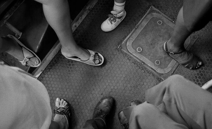 Black and white street photo capturing diverse footwear on a textured urban floor, showcasing powerful street photography moments.