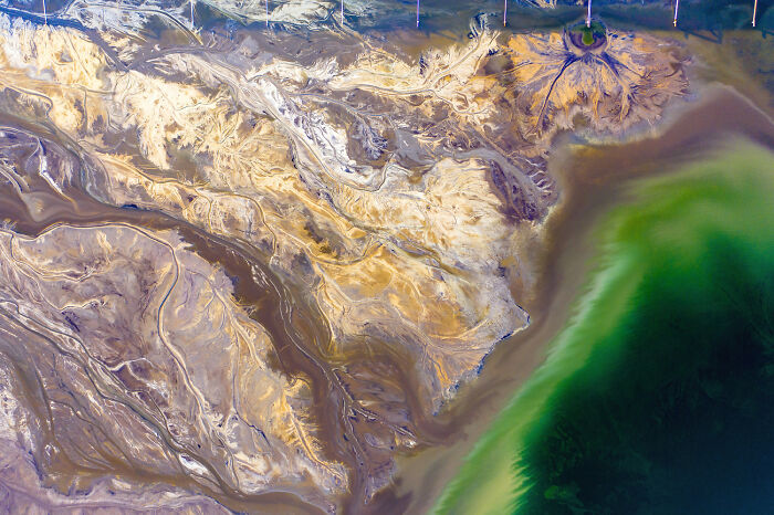 Aerial view of diverse and modern landscape in Poland showing natural and industrial features in vibrant colors.