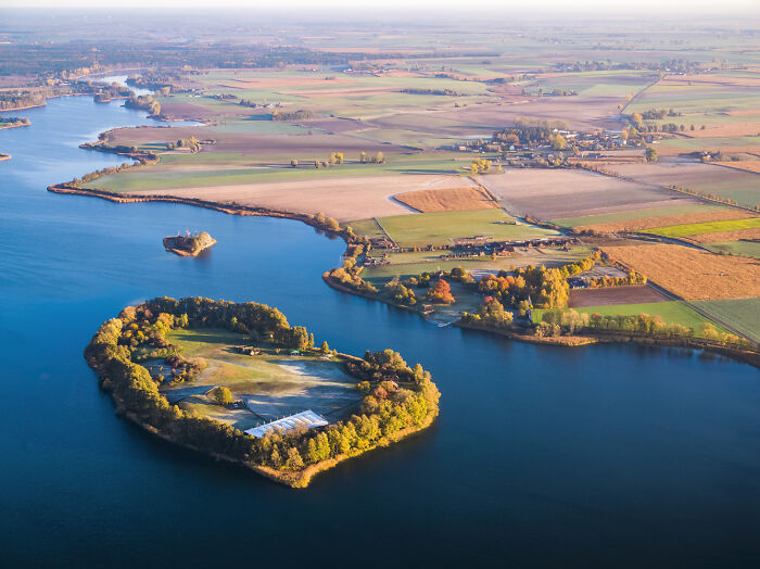 Aerial view of Poland showcasing modern and diverse landscapes with islands, rivers, and farmland in vibrant autumn colors.