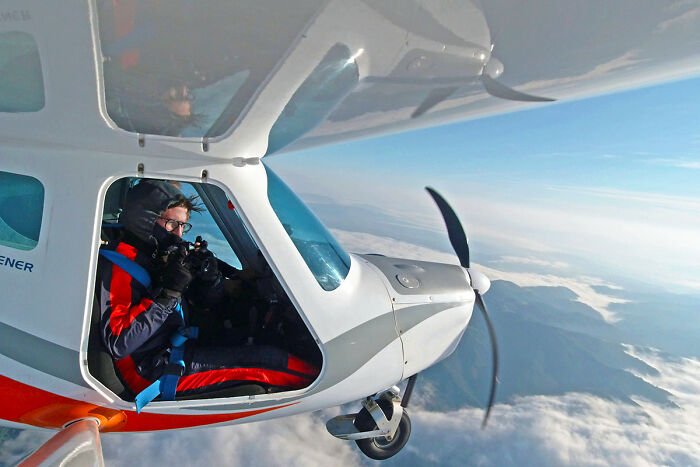 Aerial view pilot capturing modern and diverse Poland from a small airplane above clouds and mountains.
