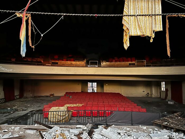 Abandoned theater with torn fabrics hanging and damaged seats showing Mayfield tornado aftermath devastation. Abandoned theater with torn fabrics hanging and damaged seats showing Mayfield tornado aftermath devastation.