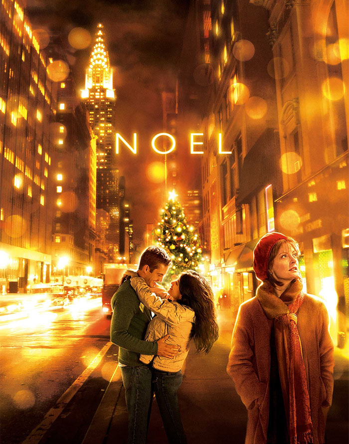 Couple embracing near Christmas tree on festive city street, with woman looking on.