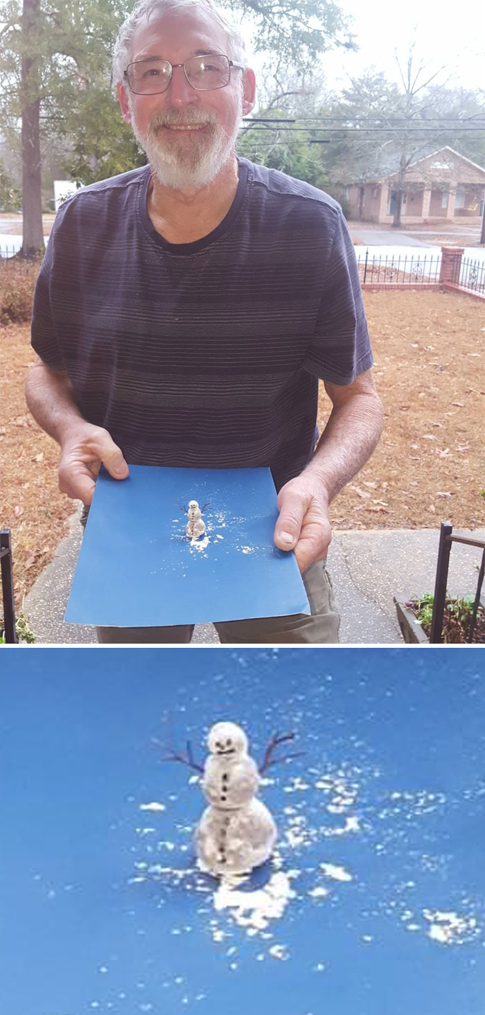 Man smiling outdoors holding a small snowman design on a blue board, showcasing a creative snowman design idea.