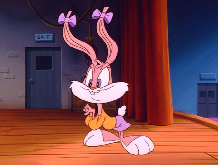 Cute animated character, pink bunny with bows, standing on stage.