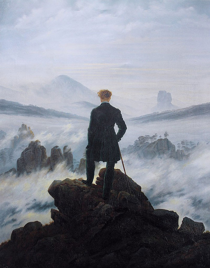 A man stands atop a rocky peak gazing over a misty landscape, in one of the most famous paintings in art history.