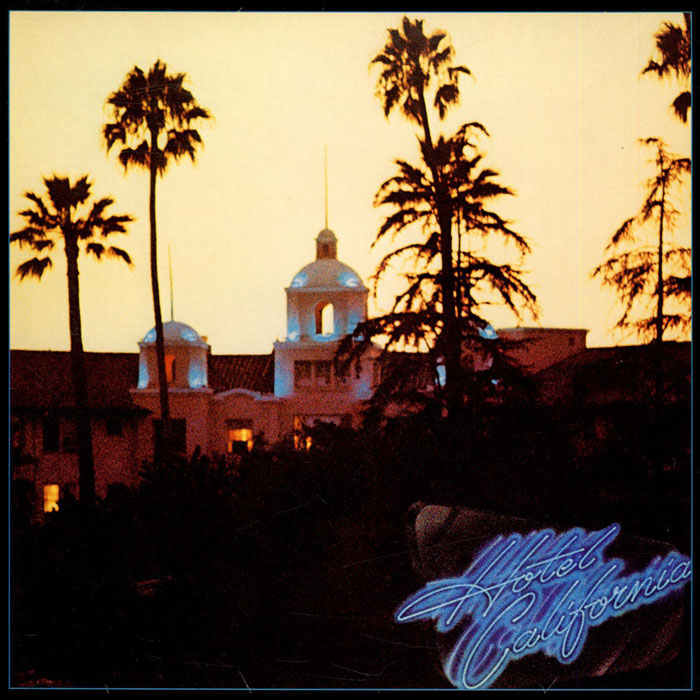 Iconic album cover with a hotel facade and palm trees at dusk.