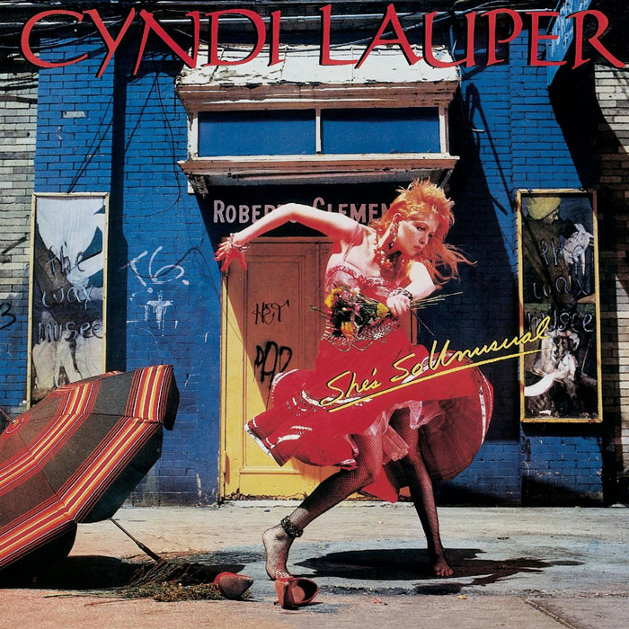 Colorful album cover featuring a woman dancing in a vibrant urban scene, representing one of the greatest album covers.