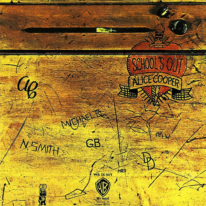 "Iconic album cover featuring a wooden school desk with carvings and a heart design for Alice Cooper's 'School's Out'."