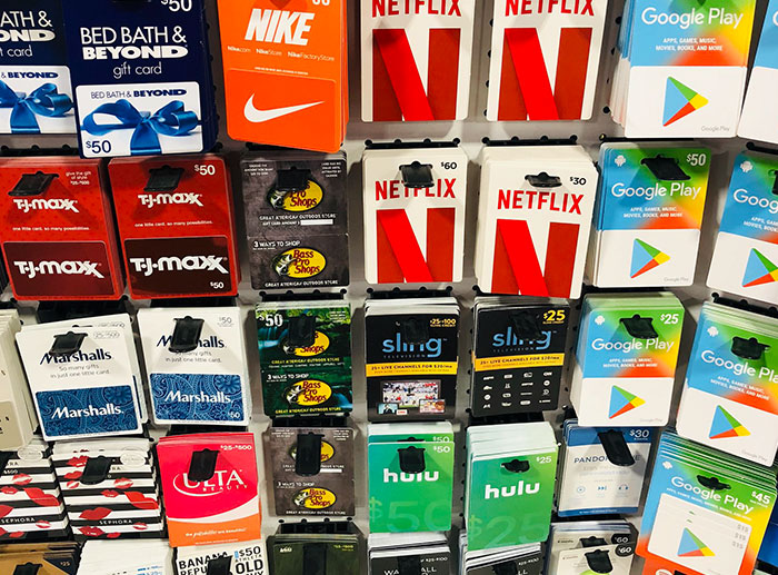 Gift cards from popular brands like Nike, Netflix, Google Play, and Hulu displayed for purchase revealing retail job secrets.