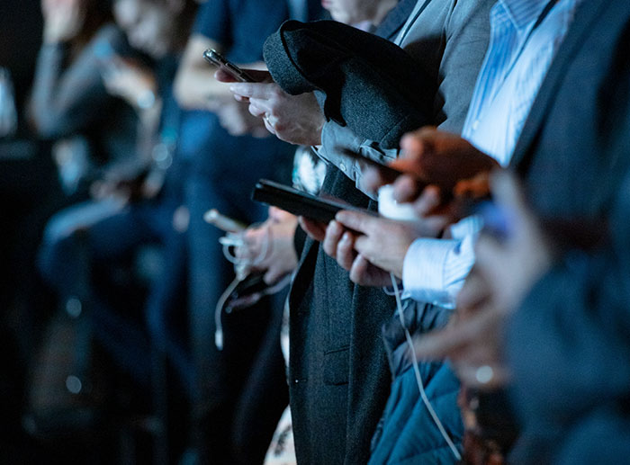 People standing in a row using smartphones, illustrating dark secrets about jobs that common people are not supposed to know.