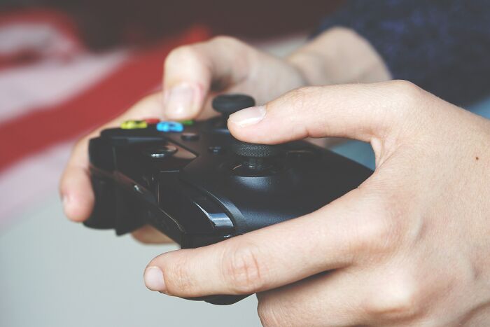 Close-up of hands holding a game controller, illustrating an unexpected twist during dates that took a weird turn.