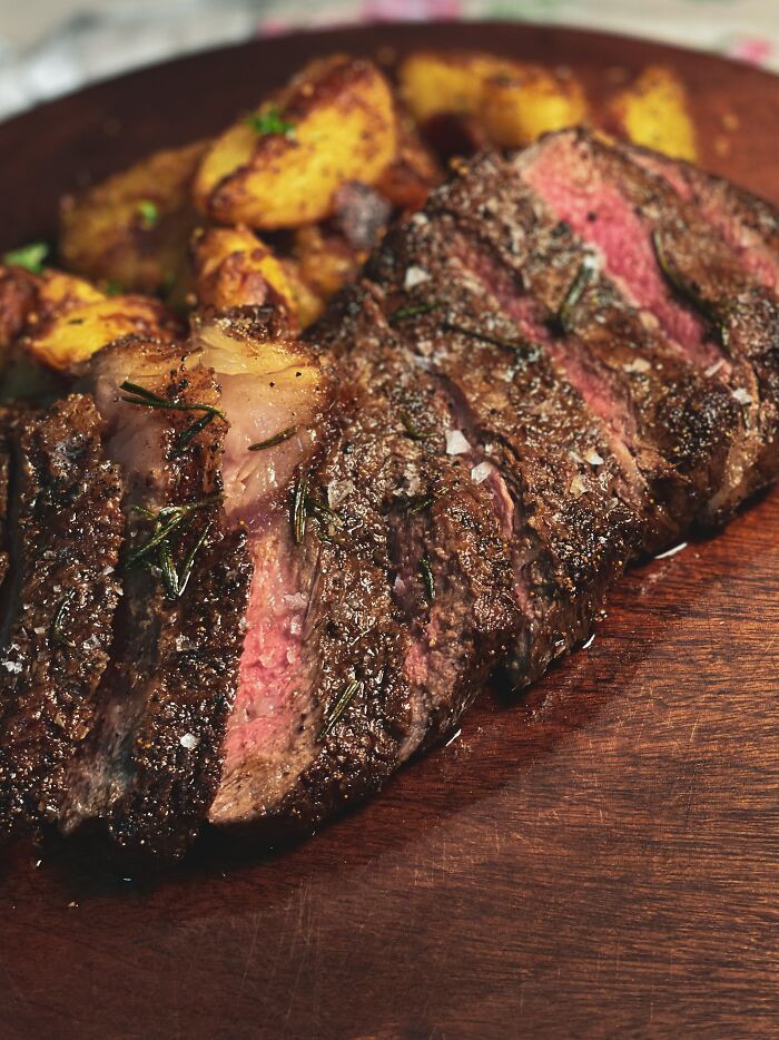 Close-up of a grilled steak with herbs and roasted potatoes, illustrating a date night meal that took a weird turn.