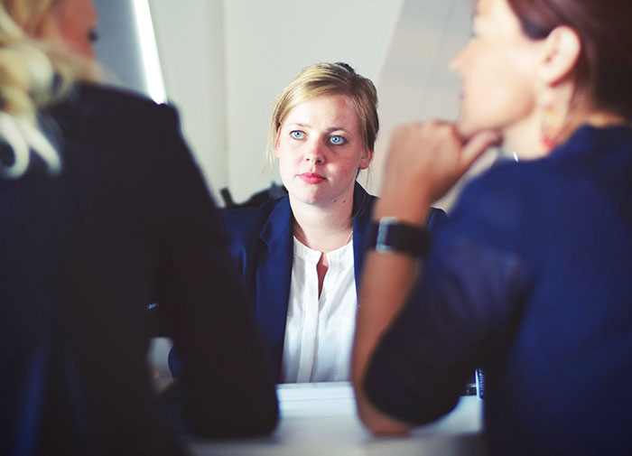 Three businesswomen sitting beside table