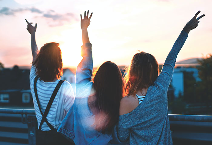 Photo of three women lifting there hands