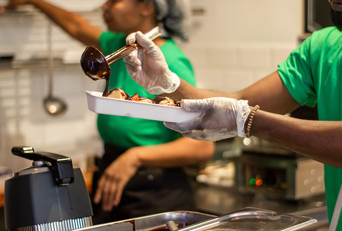 Person pouring sauce on bowl