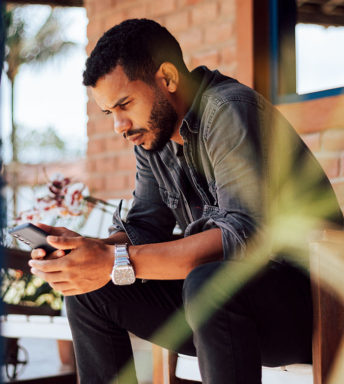 Man in gray shirt using smartphone