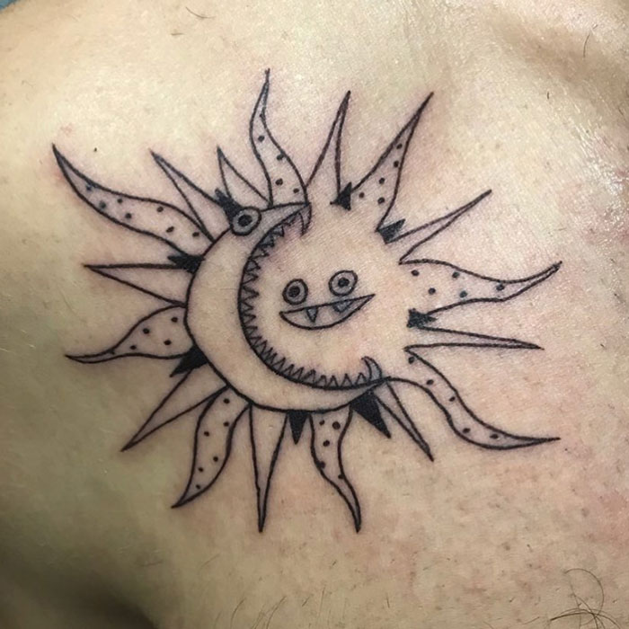Quirky tattoo design of a smiling sun and moon on skin, by a tattoo artist known for unique, imperfect drawings.