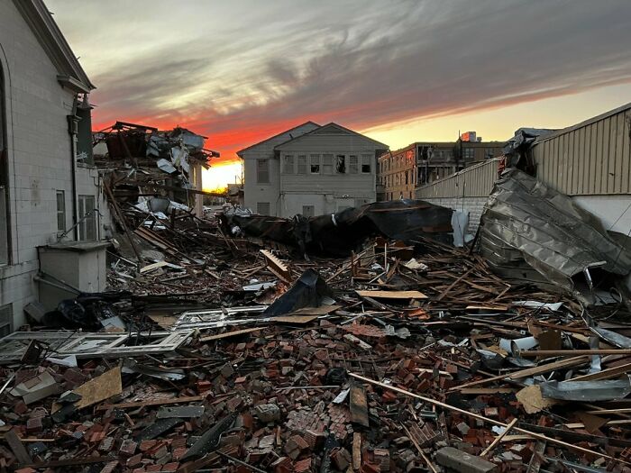 Mayfield tornado aftermath showing destroyed buildings and debris under a sunset sky. Mayfield tornado aftermath showing destroyed buildings and debris under a sunset sky.