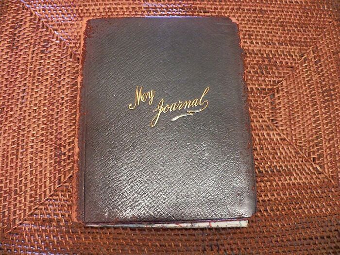 Old leather journal on woven mat representing parents' hidden secrets and personal awareness.