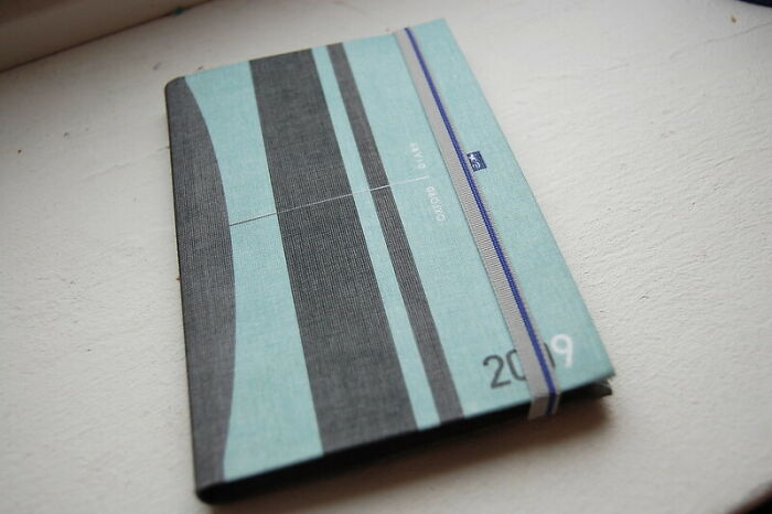 A closed 2019 planner lying on a white surface, symbolizing parents' horrid secrets being kept hidden.