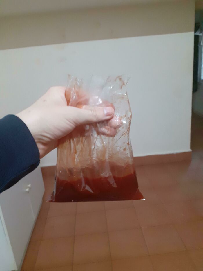 Hand holding a plastic bag of sauce, a unique example of school lunches from around the world.