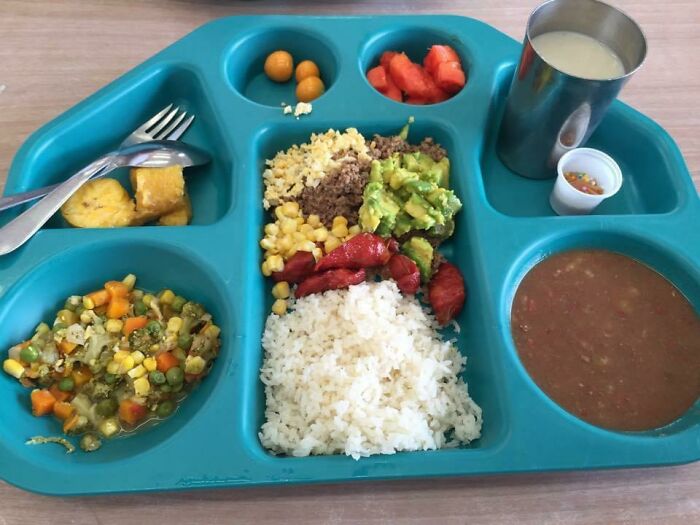 School lunch tray with rice, vegetables, meat, soup, fruit, and a drink showcasing global school lunches.
