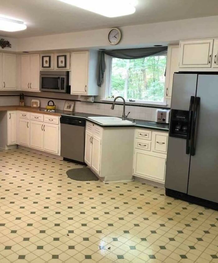 Awful kitchen interior with mismatched flooring and cabinet design, questioning designer's choices.