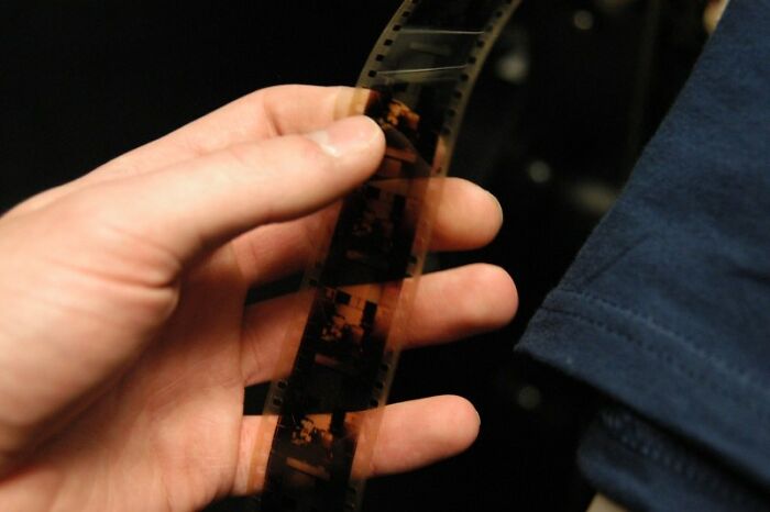 Hand holding old photographic film strip, representing hidden family secrets you might be aware of without your parents knowing.