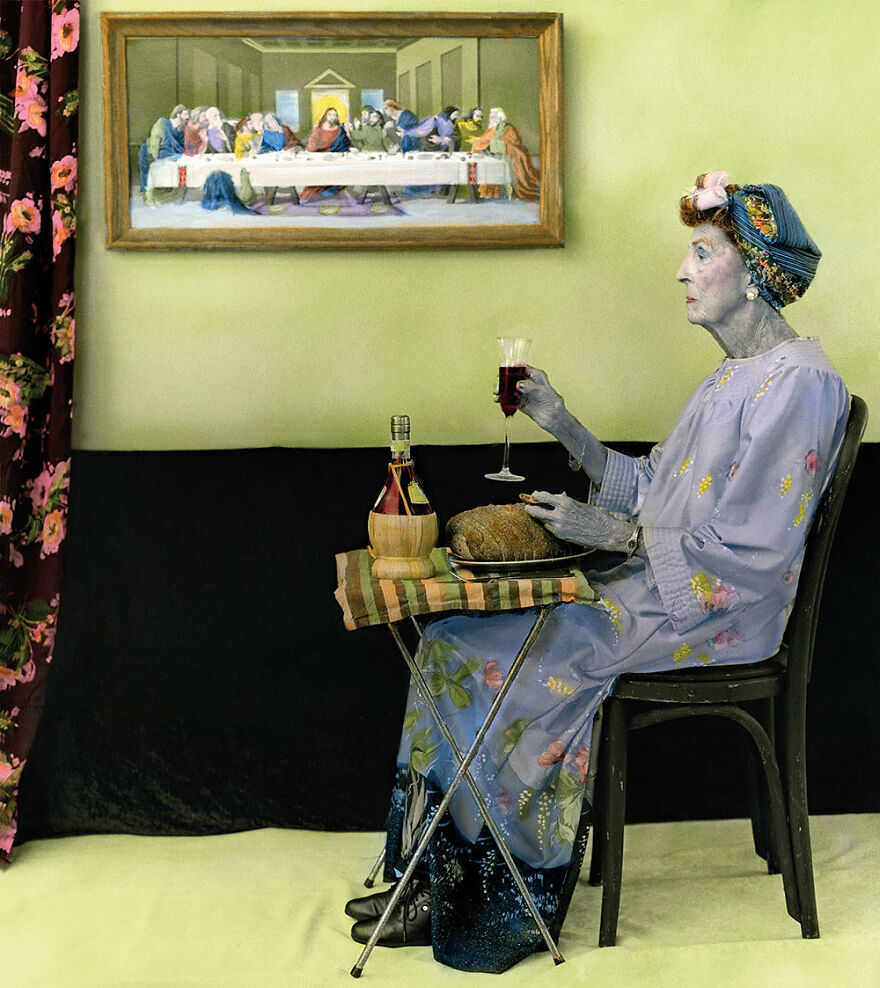 Woman captured by a photographer holding wine and bread, seated indoors with a painting in the background, showcasing beautiful women.