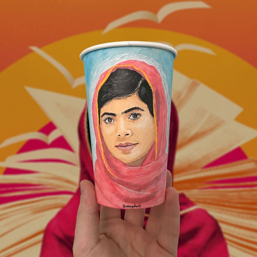 Hand holding a paper cup with a detailed illustration of a woman’s face, showcasing art on paper cups.