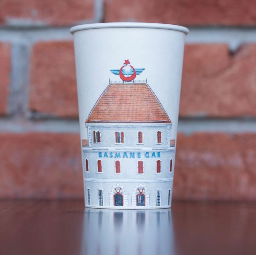 Paper cup with detailed travel illustration of a historic building, showcasing artist's drawings on paper cups while traveling.