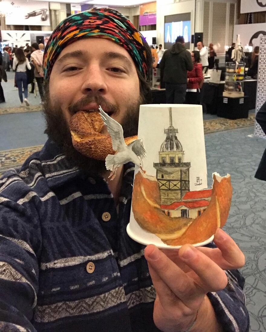 Man holding a paper cup with detailed travel-themed illustration including a seagull and tower, showcasing paper cup art.