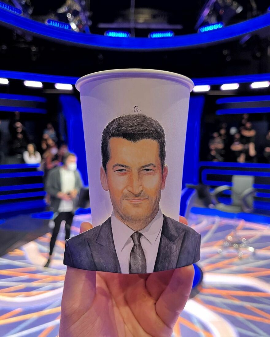 Paper cup illustration of a man in a suit, showcasing detailed artwork from an artist drawing on paper cups while traveling.